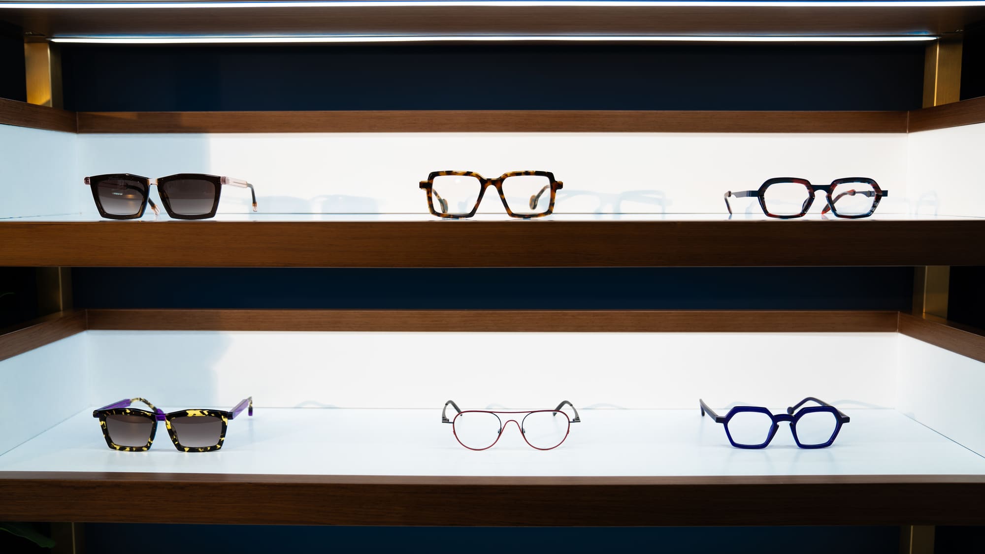 Designer frames displayed on illuminated shelves